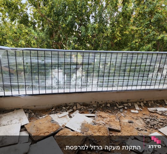מעקה מתכת עם ניילון נצמד על רקע עצים